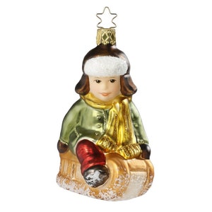 Collectible hand-blown and hand-painted glass tree ornament Boy on a sleigh. Made in the traditional method by the best European craftsmen.