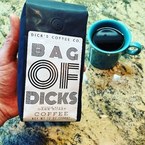 May include: A black bag of coffee with the text "DICK'S COFFEE CO. BAG OF DICKS WHOLE BEAN DARK ROAST COFFEE NET WT 12 OZ (340G)" printed on the front.