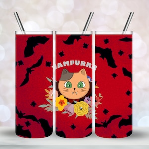 Peut inclure: Un gobelet rouge et noir avec un mignon chat de dessin animé habillé en vampire. Le gobelet a un motif floral et le texte "Vampurr" sur le devant.
