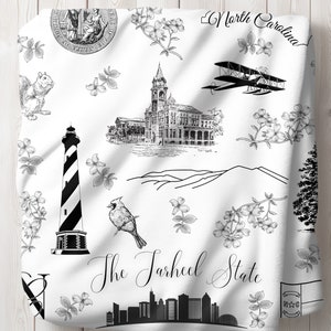 Peut inclure: Illustration en noir et blanc de divers monuments et symboles de la Caroline du Nord, notamment un phare, une ville, un cardinal, un avion, un &eacute;cureuil, une cha&icirc;ne de montagnes et le texte "The Tarheel State".