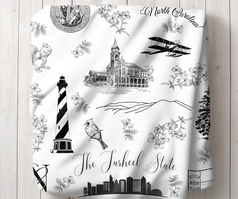 Peut inclure: Illustration en noir et blanc de divers monuments et symboles de la Caroline du Nord, notamment un phare, une ville, un cardinal, un avion, un &eacute;cureuil, une cha&icirc;ne de montagnes et le texte "The Tarheel State".