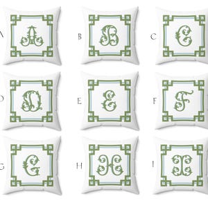 Peut inclure: Neuf coussins carr&eacute;s blancs, chacun avec une lettre brod&eacute;e diff&eacute;rente dans une police verte orn&eacute;e. Les lettres sont encadr&eacute;es par un motif de bordure g&eacute;om&eacute;trique vert et bleu clair.