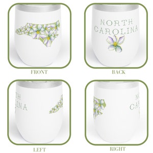 May include: White stainless steel tumbler with a green outline of the state of North Carolina and white flowers. The back of the tumbler says "NORTH CAROLINA" with a single white flower.