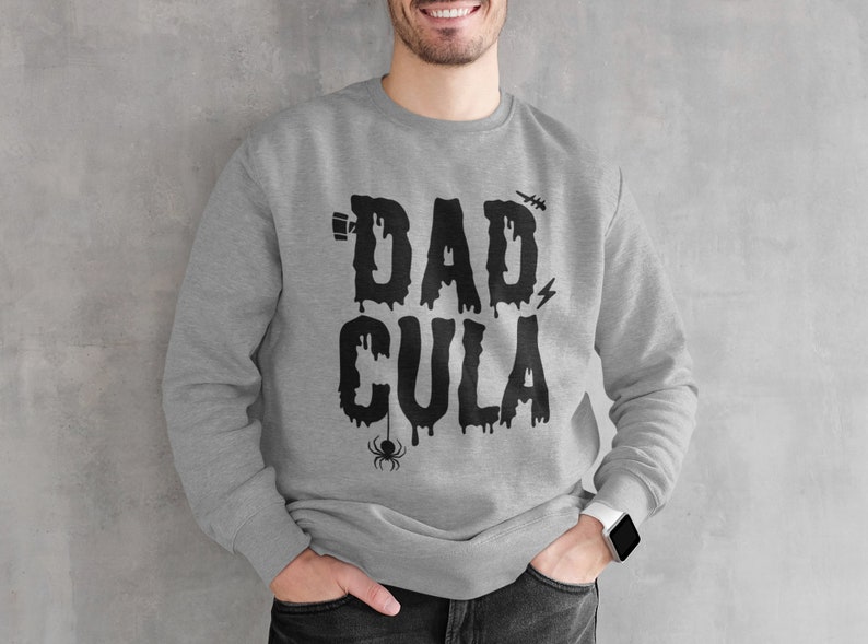 May include: A gray sweatshirt with a black graphic that says "Dadcula" with dripping letters and a spider.