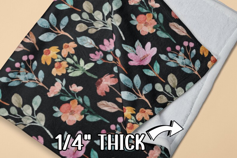 May include: A black blanket with a floral pattern featuring pink, yellow, and blue flowers and leaves. The blanket is 1/4 inch thick and has a white backing.