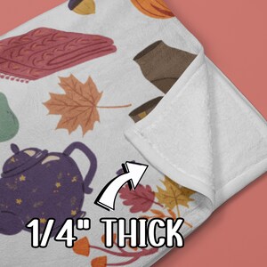 Puede incluir: Una manta de forro polar blanca con un patr&oacute;n de tem&aacute;tica oto&ntilde;al que incluye teteras, peras, bellotas, hojas y una manta de punto. La manta tiene un grosor de 0,6 cm.