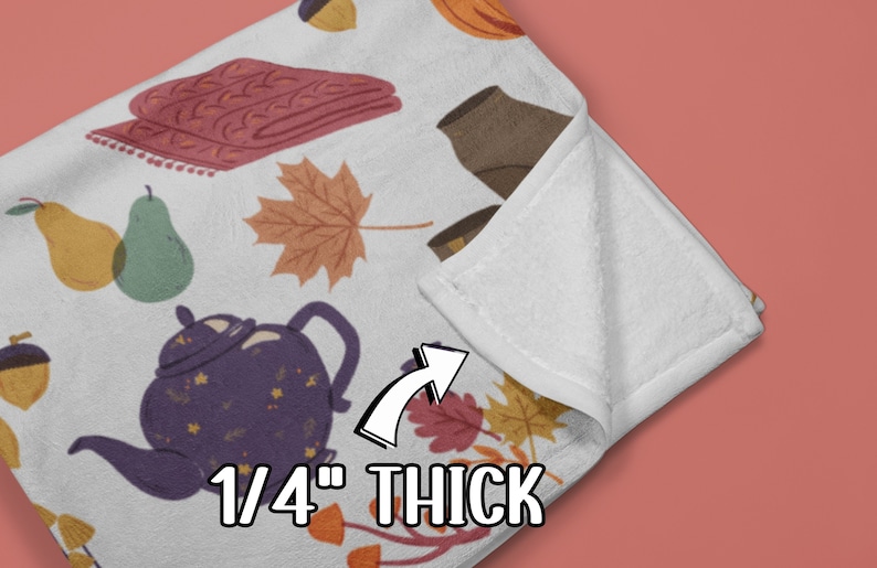 Puede incluir: Una manta de forro polar blanca con un patr&oacute;n de tem&aacute;tica oto&ntilde;al que incluye teteras, peras, bellotas, hojas y una manta de punto. La manta tiene un grosor de 0,6 cm.