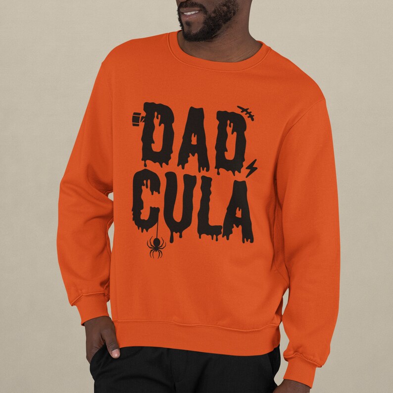 May include: Orange sweatshirt with black text that reads "DAD CULA" with a dripping effect and a spider graphic.