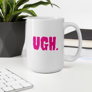 May include: White ceramic coffee mug with a pink "UGH." graphic.