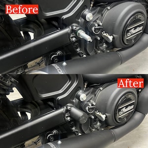 Peut inclure: Gros plan sur un moteur de moto avec un carter en métal noir. Le carter porte un logo Indian argenté et un boulon en métal noir. L'image montre le moteur avant et après une modification. La modification comprend un capuchon en métal noir sur le boulon.