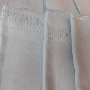 May include: A white ceramic mug with a black handle and the text "But First, Coffee" in a bold, black font. The mug is set against a neutral background, highlighting its simple design.