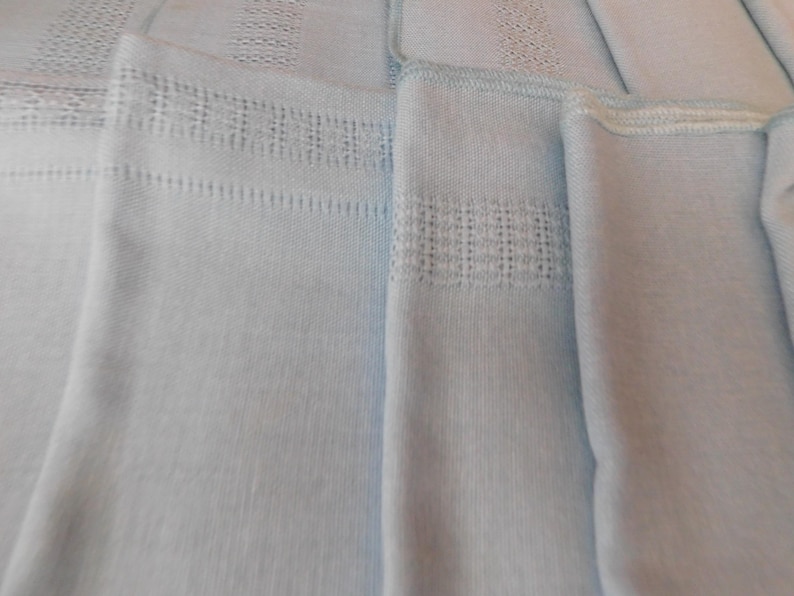 May include: A white ceramic mug with a black handle and the text "But First, Coffee" in a bold, black font. The mug is set against a neutral background, highlighting its simple design.