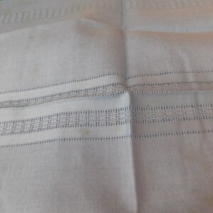 May include: A white ceramic mug with a black handle and the text "But First, Coffee" in a black, handwritten-style font. The mug is on a white surface.