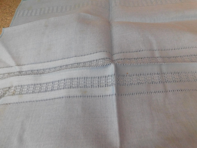 May include: A white ceramic mug with a black handle and the text "But First, Coffee" in a black, handwritten-style font. The mug is on a white surface.