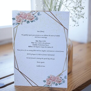 Könnte beinhalten: Eine Hochzeitseinladung mit einem goldenen geometrischen Rahmen und rosafarbenen floralen Akzenten. Die Einladung enthält die Namen Isabella und Steve, das Datum 8. Mai 2024 und den Ort Enchantment Resort in Sedona, Arizona.