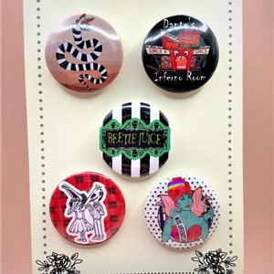 May include: Set of four round button pins featuring characters and imagery from the movies Beetlejuice and The Nightmare Before Christmas. The pins are black, white, red, and green with various graphic designs.
