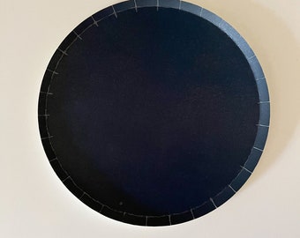 May include: A black round paper plate with a white scalloped edge.