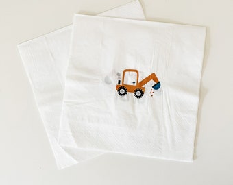 Peut inclure: Deux serviettes en papier blanches avec une illustration de véhicule de chantier marron et bleu. Le véhicule a une cheminée noire et des roues noires.
