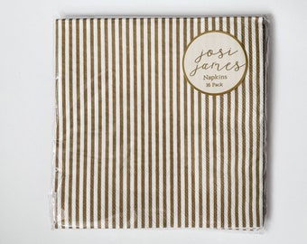 Peut inclure: Un paquet de 16 serviettes en papier rayées blanches et dorées avec une étiquette ronde qui dit "josi james Napkins 16 Pack".
