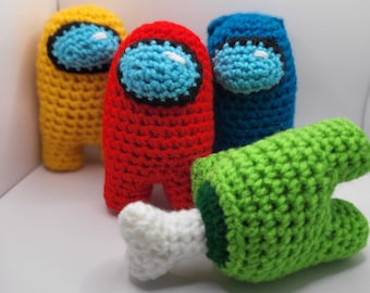 May include: Four crocheted Among Us characters, one yellow, one red, one blue, and one green. The green character is lying on its side with a white bone.