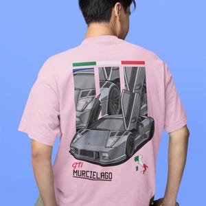 May include: Pink t-shirt featuring a graphic of a grey Lamborghini Murcielago with the text "GTI Murcielago" printed on the front.