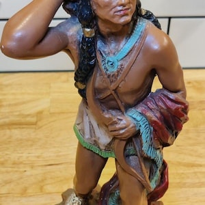 Figura de nativo americano con arco y flechas, de Universal Statuario Corp., año 1976.