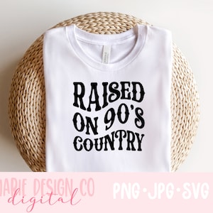May include: White t-shirt with black text that reads "Raised on 90's Country".