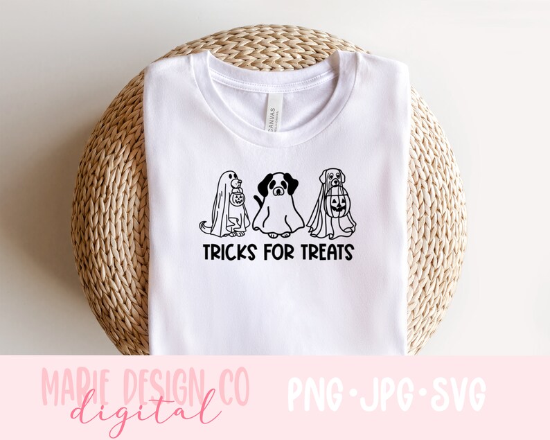 K&ouml;nnte beinhalten: Wei&szlig;es T-Shirt mit einer schwarz-wei&szlig;en Illustration von drei Hunden, die f&uuml;r Halloween in Geisterkost&uuml;men gekleidet sind. Der Text "TRICKS FOR TREATS" ist unter den Hunden gedruckt.