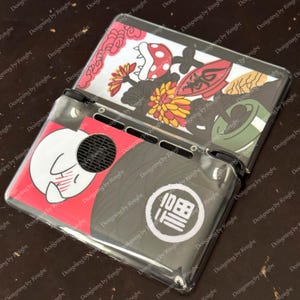 May include: Clear plastic Nintendo Switch case with colorful Japanese-inspired artwork. The design includes a white rabbit, flowers, and a Japanese character. The case is open, revealing the screen and controls.