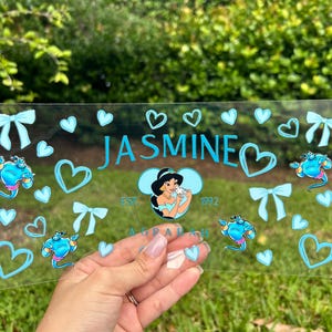 May include: A rustic wooden sign with the text "Welcome" in a handwritten style. The sign is painted white with a distressed finish, and a small, decorative heart is attached to the bottom. The background is a blurred image of a wooden surface.