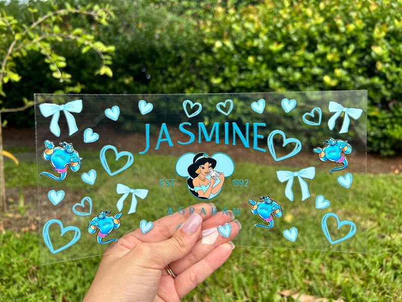 May include: A rustic wooden sign with the text "Welcome" in a handwritten style. The sign is painted white with a distressed finish, and a small, decorative heart is attached to the bottom. The background is a blurred image of a wooden surface.