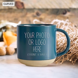 May include: A teal blue ceramic mug with a beige bottom. The mug has the text "Your photo or logo here (front & back)" printed on the front.