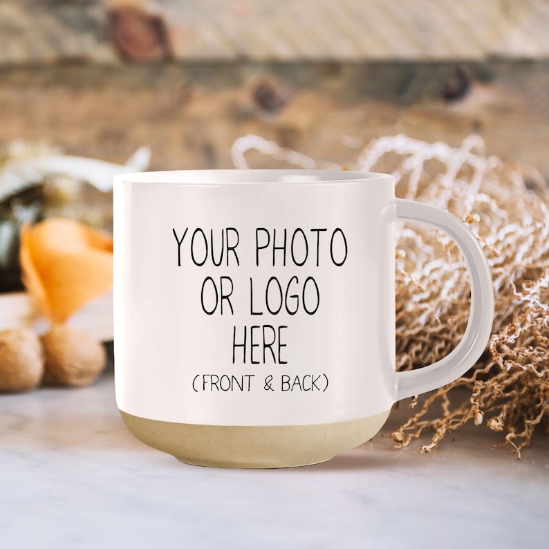 Op de afbeelding: Een witte keramische mok met een beige bodem. De mok heeft een handvat en er staat "YOUR PHOTO OR LOGO HERE (FRONT & BACK)" op.