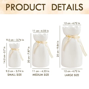 Peut inclure: Trois vases en c&eacute;ramique blanche avec des bords festonn&eacute;s et nou&eacute;s avec un ruban beige. Le petit vase mesure 14,5 cm de haut, le vase moyen mesure 20 cm de haut et le grand vase mesure 25 cm de haut. Le texte "PRODUCT DETAILS" est en haut.
