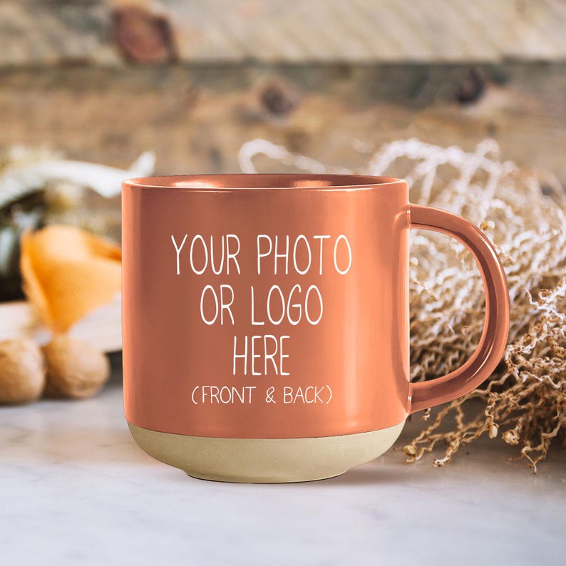 Op de afbeelding: Een terracottakleurige keramische mok met een witte handgreep. De mok heeft een witte inscriptie met de tekst "Uw foto of logo hier (voor- en achterkant)".