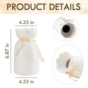 Peut inclure: Un vase en c&eacute;ramique blanc avec un dessus festonn&eacute; et un ruban dor&eacute; nou&eacute; autour du col. Le vase mesure 17,45 cm de haut et 11 cm de large. L'image comprend le texte "PRODUCT DETAILS".