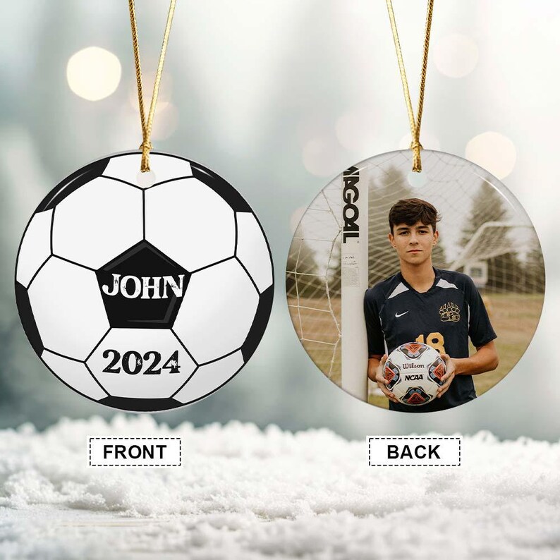 May include: A personalized soccer ornament with a soccer ball design on the front, featuring the name "JOHN" and the year "2024." The back displays a photo of a young man holding a soccer ball near a goal.