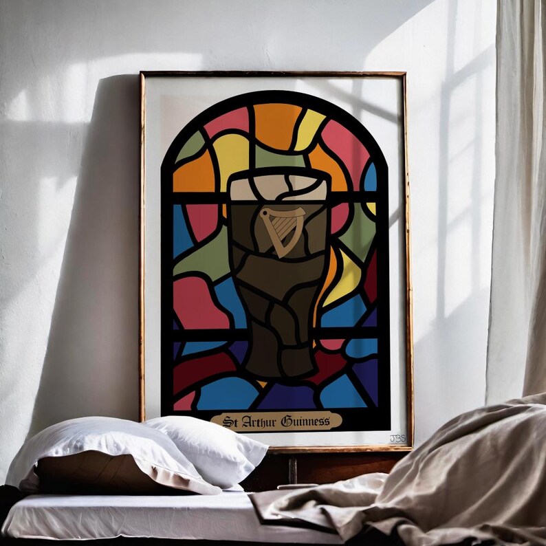 May include: A framed print of a stained glass window design featuring a glass of Guinness beer with the text "St. Arthur Guinness" at the bottom.