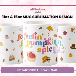 May include: Two white mugs with a fall-themed design. The mugs are 11oz and 15oz. The design features the text "feelin pumpkin spicy" in rainbow colors and various fall-themed illustrations.