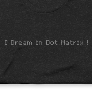 Peut inclure: T-shirt noir avec le texte "I Dream in Dot Matrix!" imprimé en blanc.