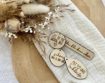 May include: Three wooden tags with handwritten messages. The first tag is round and says "Lieb du mir wichtig bist" with a heart. The second tag is round and says "Schon dass es dich gibt". The third tag is shaped like a teardrop and says "Mit und Schleife" with a heart.