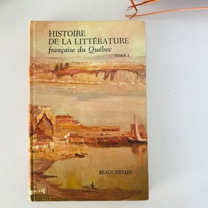 May include: A vintage book titled "HISTOIRE DE LA LITTÉRATURE française du Québec TOME I" by BEAUCHEMIN. The cover features a watercolour painting of a waterfront scene with buildings, a river, and boats.