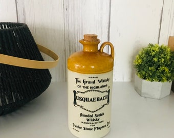 Puede incluir: Una botella de cerámica con un tapón de corcho, que presenta una etiqueta que dice "Old-Rare The Grand Whisky of the Highlands Usquaebech Blended Scotch Whisky Blended & Bottled for Twelve Stone Flagons Ltd."