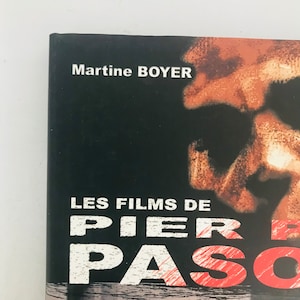 以下が含まれることがあります： 白と赤の文字で「LES FILMS DE PIER PASO」というタイトルが書かれた本の表紙。著者の名前「Martine BOYER」が上部に白で表示されています。背景は黒で、ぼやけた画像があります。