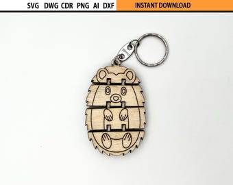 May include: A wooden hedgehog keychain with a metal keyring. The hedgehog design is made of layered wood pieces, with etched details for the face, paws, and quills. The keychain has the text "FRANCE" on the metal piece.