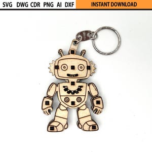 May include: A wooden robot keychain with a silver keyring. The robot has a detailed design with gears, square eyes, and antenna-like features. The keychain is made of light-colored wood and is a fun accessory.