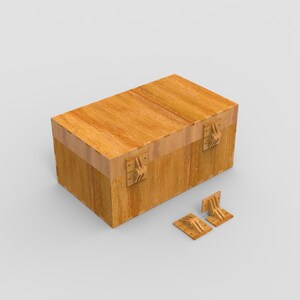 May include: A rectangular wooden box with a hinged lid and decorative metal hardware. The box is light brown with visible wood grain. Two matching metal hinges are positioned next to the box.