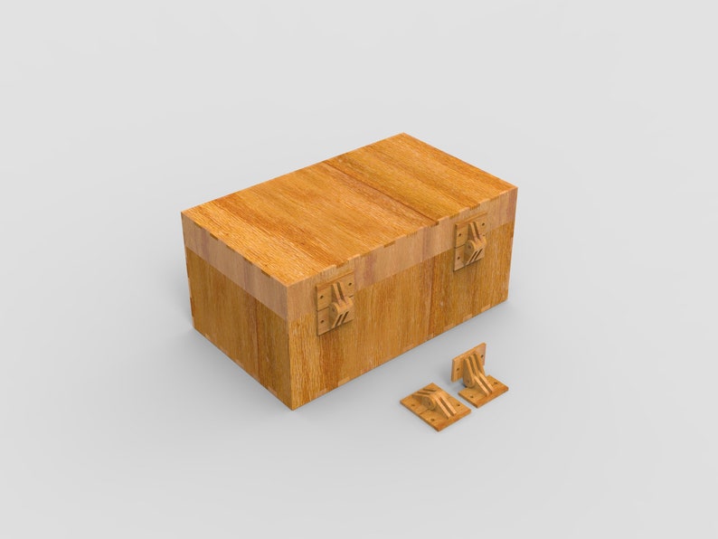 May include: A rectangular wooden box with a hinged lid and decorative metal hardware. The box is light brown with visible wood grain. Two matching metal hinges are positioned next to the box.