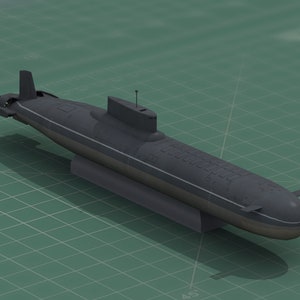 May include: A dark grey submarine model with a streamlined design. The model features a conning tower, a fin, and a lower hull section. The submarine is set against a green grid background, suggesting a workspace or a model-making environment.
