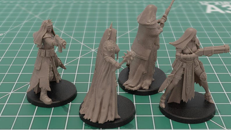 Op de afbeelding: Vier ongeverfde lichtbruine hars miniatuurfiguren op ronde zwarte voetstukken. De figuren tonen gepantserde personages in lange gewaden, sommigen houden geweren vast en &eacute;&eacute;n houdt een knots met stekels, allemaal met gedetailleerde tactische uitrusting.